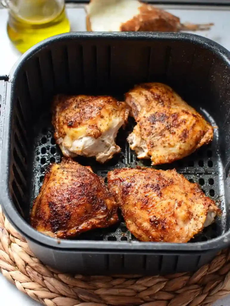 Air Fryer Mediterranean Chicken 4 Four crispy Air Fryer Mediterranean Chicken thighs in a black air fryer basket