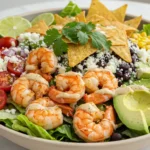 Shrimp Taco Salad Magic – The 1 Recipe You Need Today! 11 A vibrant and delicious Shrimp Taco Salad served in a bowl, topped with juicy shrimp, crispy tortilla chips, fresh vegetables, and a creamy dressing.