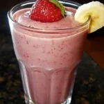 The BEST Strawberry Banana Smoothie Recipe (Ready in 5 Min!) 15 Glass of strawberry banana smoothie topped with a fresh strawberry and banana slice.