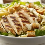 close up view of creamy Chicken Caesar Salad Pasta with grilled chicken and lettuce