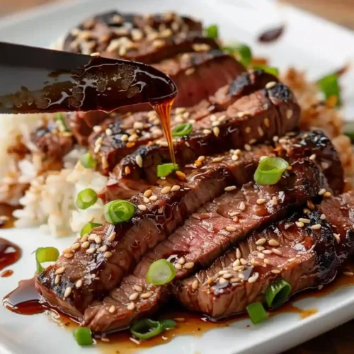 The Ultimate Teriyaki Beef Steak Recipe Guide 4 Sliced teriyaki beef steak arranged on plate with rice, drizzled with sauce and garnished for teriyaki beef steak recipe