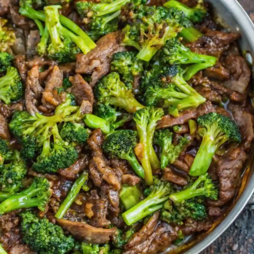 Close-up of beef and broccoli stir-fry in a stainless steel skillet