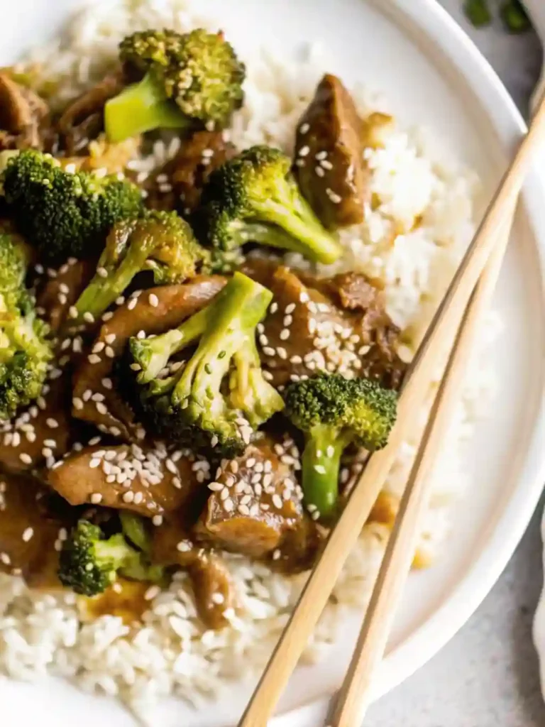 The Best Takeout-Style Chinese Beef and Broccoli Stir Fry 8 Chinese beef and broccoli with sesame seeds served on white rice with chopsticks