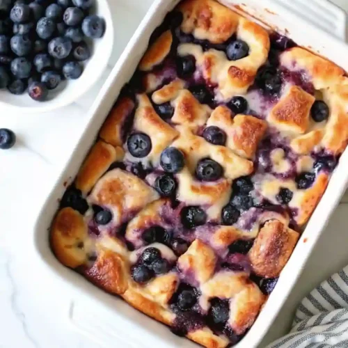 Blueberry French Toast Casserole 4 Blueberry French Toast Casserole topped with fresh blueberries in a white baking dish