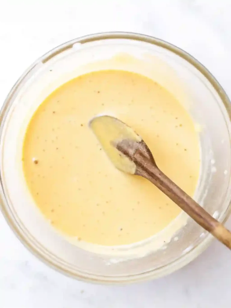 5-Star Pineapple Ice Cream Recipe You'll Crave 6 Creamy custard mixture in a bowl with a wooden spoon for pineapple ice cream
