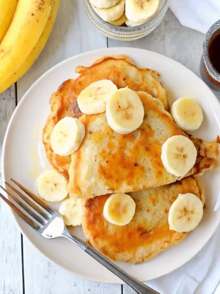 Brown Sugar Banana Pancakes 3 Plate of homemade Brown Sugar Banana Pancakes topped with banana slices
