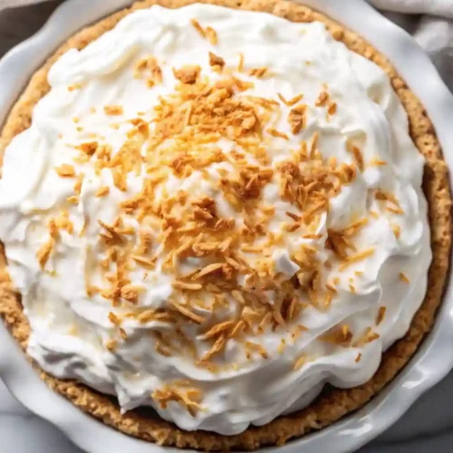 🥥 Old-Fashioned Coconut Cream Pie 4 Creamy coconut cream pie with whipped topping and toasted coconut flakes in a white pie dish
