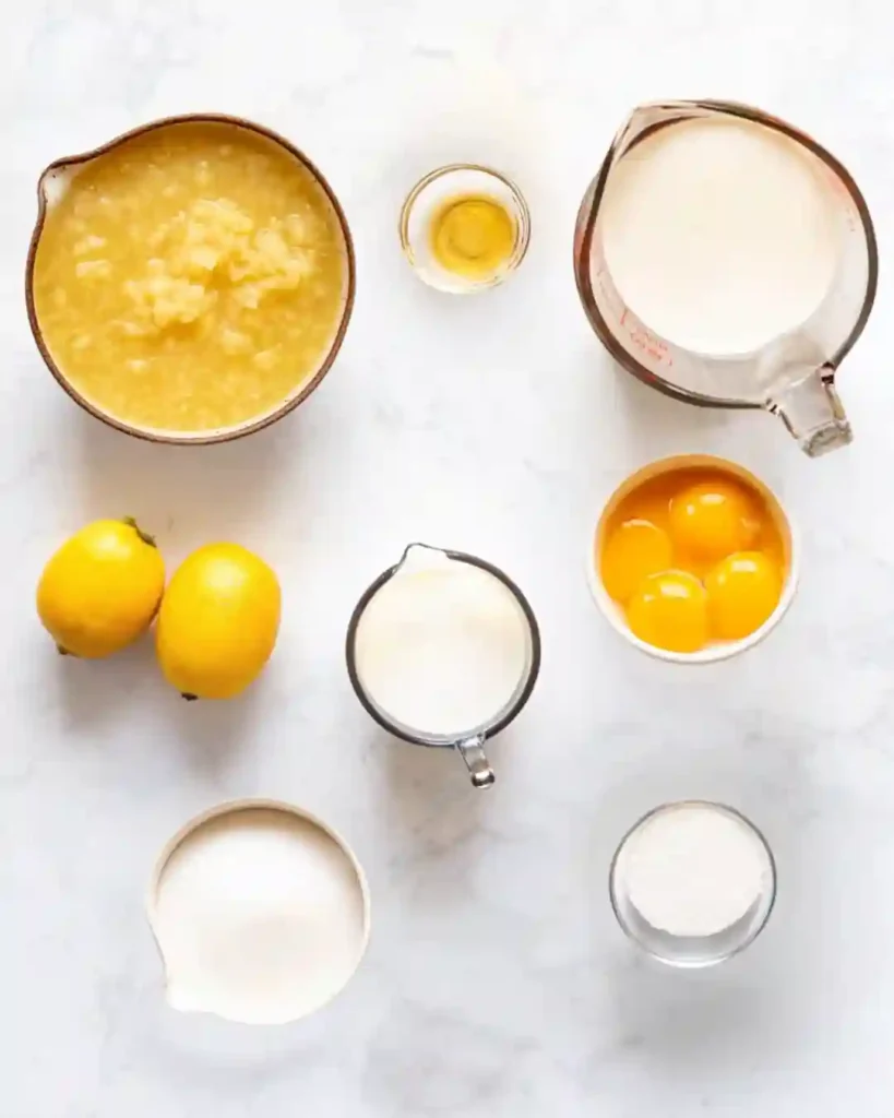 5-Star Pineapple Ice Cream Recipe You'll Crave 4 Ingredients for pineapple ice cream including pineapple, cream, sugar, eggs, and lemon on a marble surface