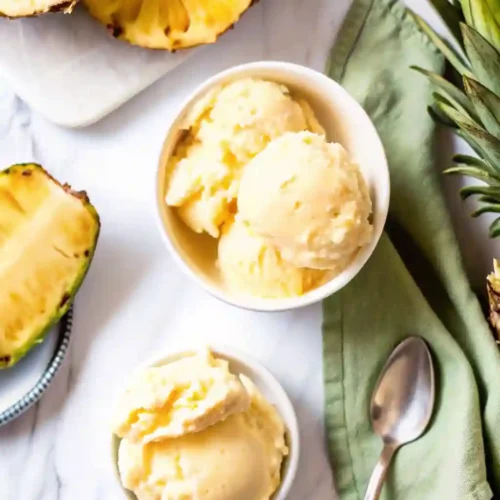 5-Star Pineapple Ice Cream Recipe You'll Crave 9 Two bowls of pineapple ice cream with fresh pineapple and green napkin