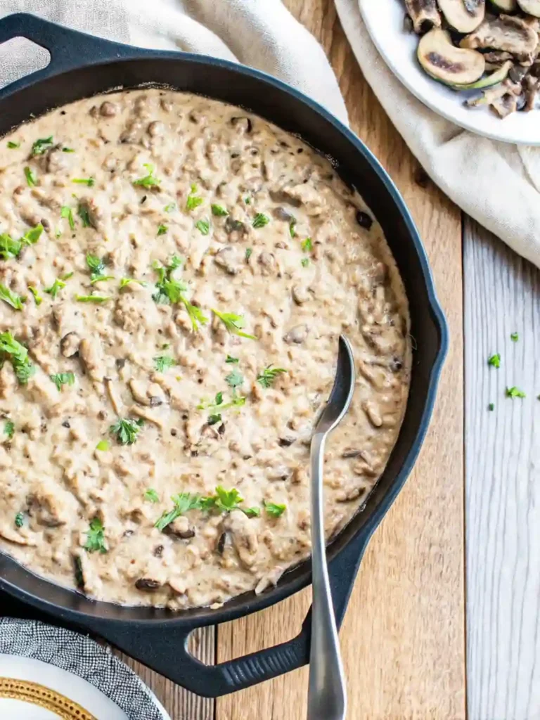 Ground Beef Stroganoff Recipe 4 Creamy ground beef stroganoff garnished with parsley in a cast iron skillet