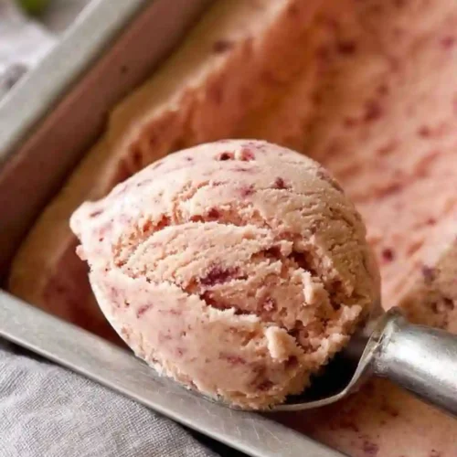 The Best Homemade Strawberry Ice Cream (Easy No-Churn Method) 6 A close-up scoop of homemade strawberry ice cream in a metal loaf pan