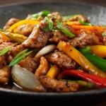 Close-up of Black Pepper Chicken with bell peppers and onions in savory sauce