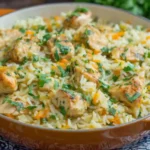 Creamy chicken and rice served in a Dutch oven, garnished with parsley