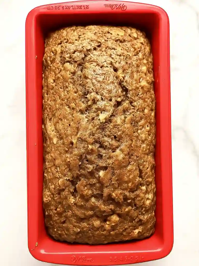 Best Zucchini Bread Recipe 6 Golden brown loaf of Zucchini Bread Recipe baked in a red loaf pan