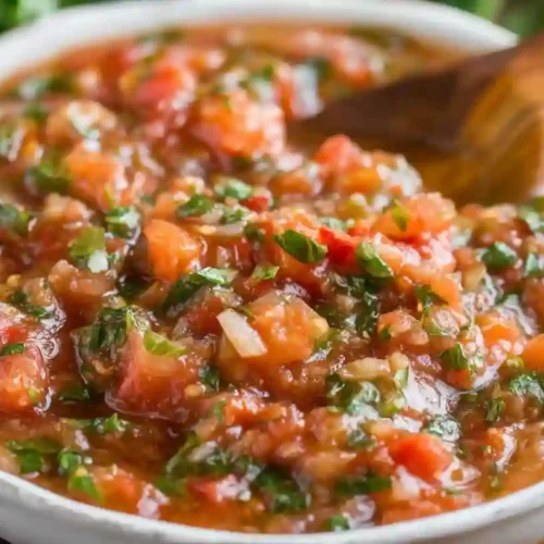 Close-up of chunky Margherita sauce made with tomatoes, basil, and garlic in a white bowl