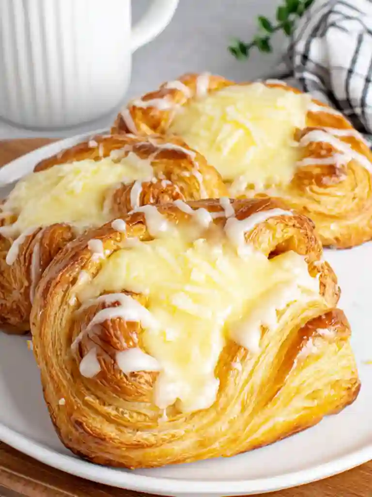Ultimate Cheese Danish Recipe 4 Cheese Danish with sweet glaze and golden flaky pastry served on a plate