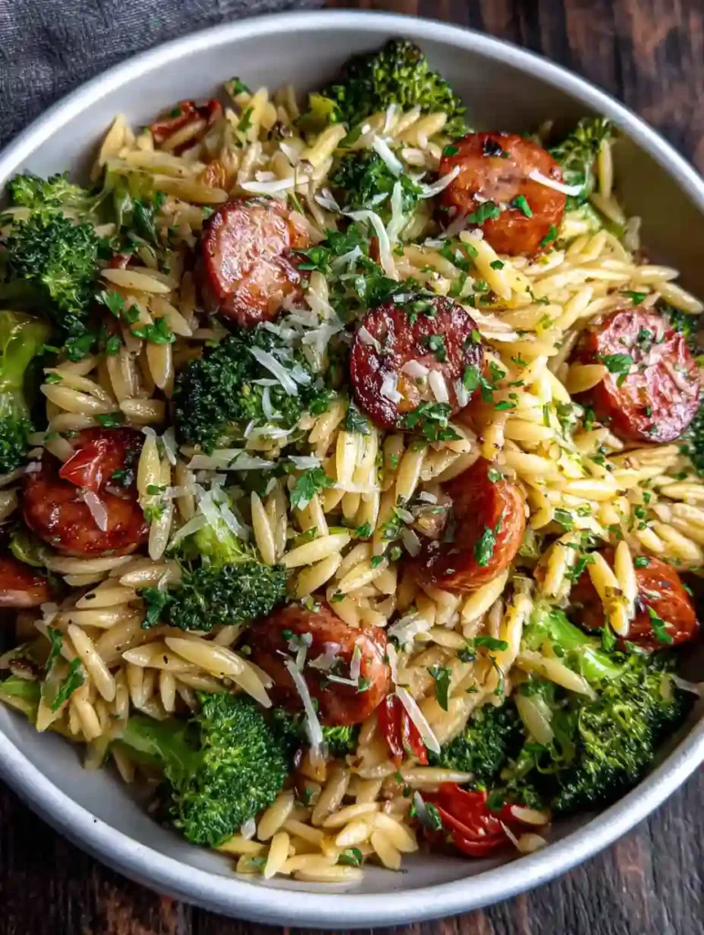 Chicken Sausage and Broccoli Orzo Recipe 2 Chicken Sausage and Broccoli Orzo topped with herbs, tomatoes, and shredded cheese