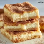 Churro Cheesecake Bars stacked on a plate with cinnamon sugar topping