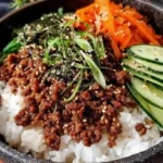 Korean Ground Beef Bulgogi served over rice with sliced cucumber, carrots, and sesame seeds