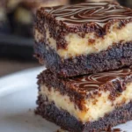Keto Cheesecake Brownies 9 Keto cheesecake brownies stacked on a plate with creamy cheesecake layers and glossy chocolate swirl