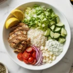 Greek chicken bowls with grilled chicken, rice, cucumber, tomatoes, feta, and tzatziki