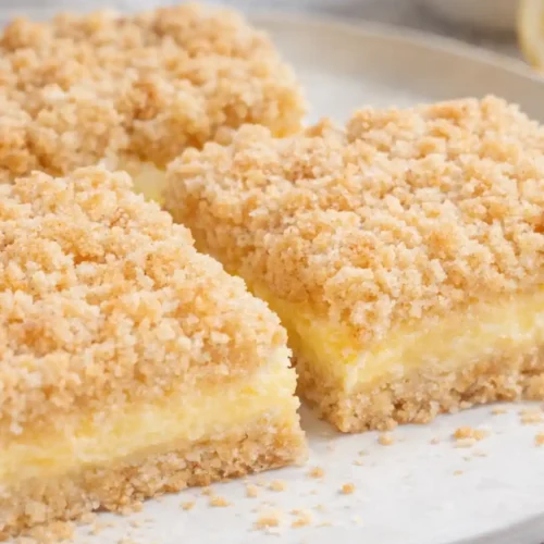 Lemon Crumb Bars with creamy lemon filling and golden buttery crumb topping on a white plate