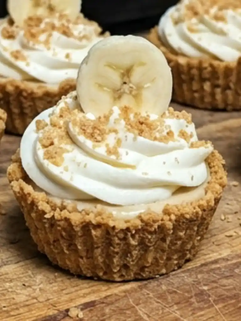 Close up of No-bake Mini Banana Cream Pies with whipped topping and banana slice