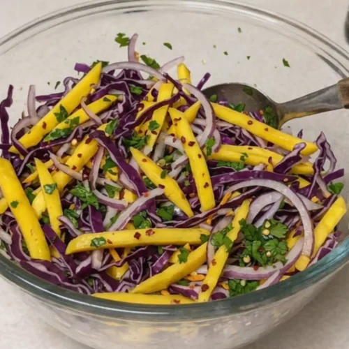 Colorful mango slaw with red cabbage, onions, herbs, and lime dressing