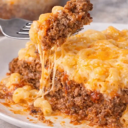 Mac and Cheese Meatloaf Casserole 4 Close up of Mac and Cheese Meatloaf Casserole slice with melted cheese and seasoned beef layers