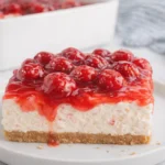 No Bake Cherry Cheesecake slice with graham crust and cherry topping on white plate