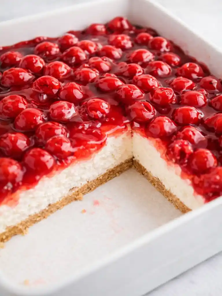 No Bake Cherry Cheesecake in white baking dish with cherry topping and graham crust