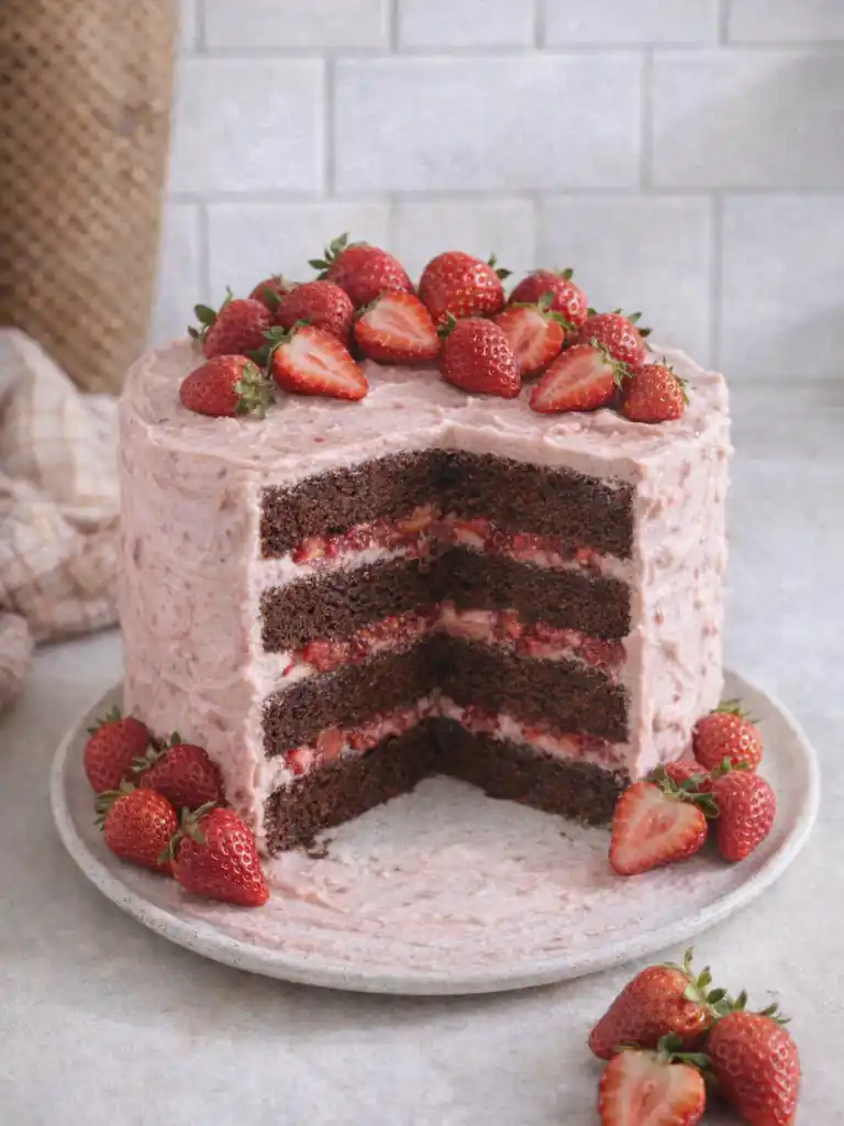 Strawberry chocolate cake with pink frosting and fresh strawberry layers inside