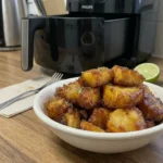 Air fryer pineapple chunks caramelized in a bowl with golden edges and glossy finish on a kitchen counter