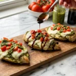 Pesto Bruschetta Chicken topped with melted mozzarella, fresh tomatoes, basil pesto, and balsamic glaze