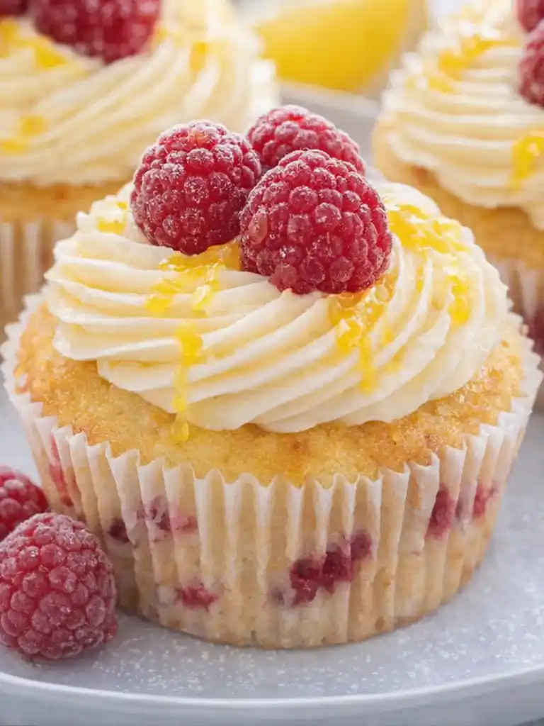 Close up of Lemon Raspberry Cupcakes with buttercream and fresh raspberries on top
